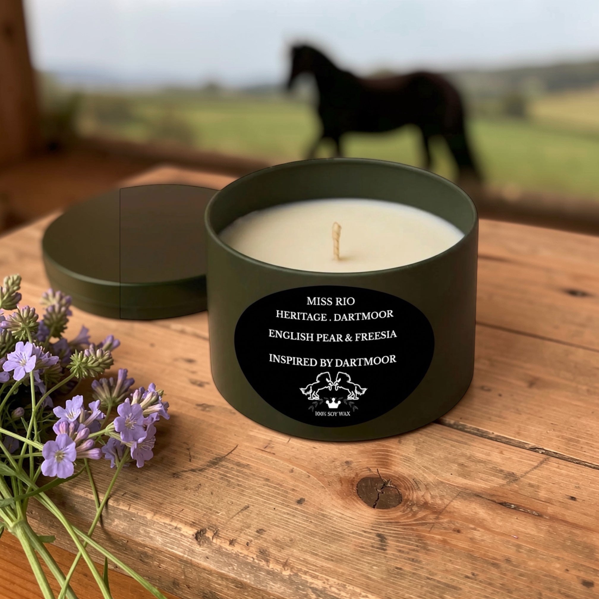 Luxury soy Candle in a green container with a horse in the background on a wooden surface