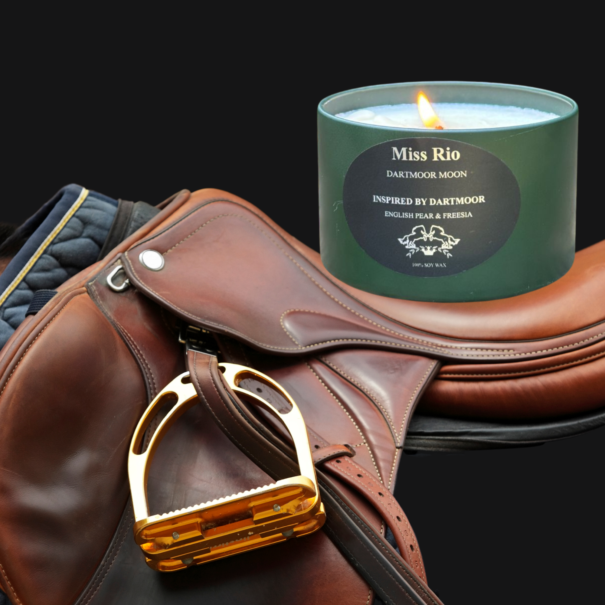 Luxury English Pear & Freesia soy candle by Miss Rio displayed on a leather saddle with stirrup, inspired by Dartmoor and equestrian heritage.
