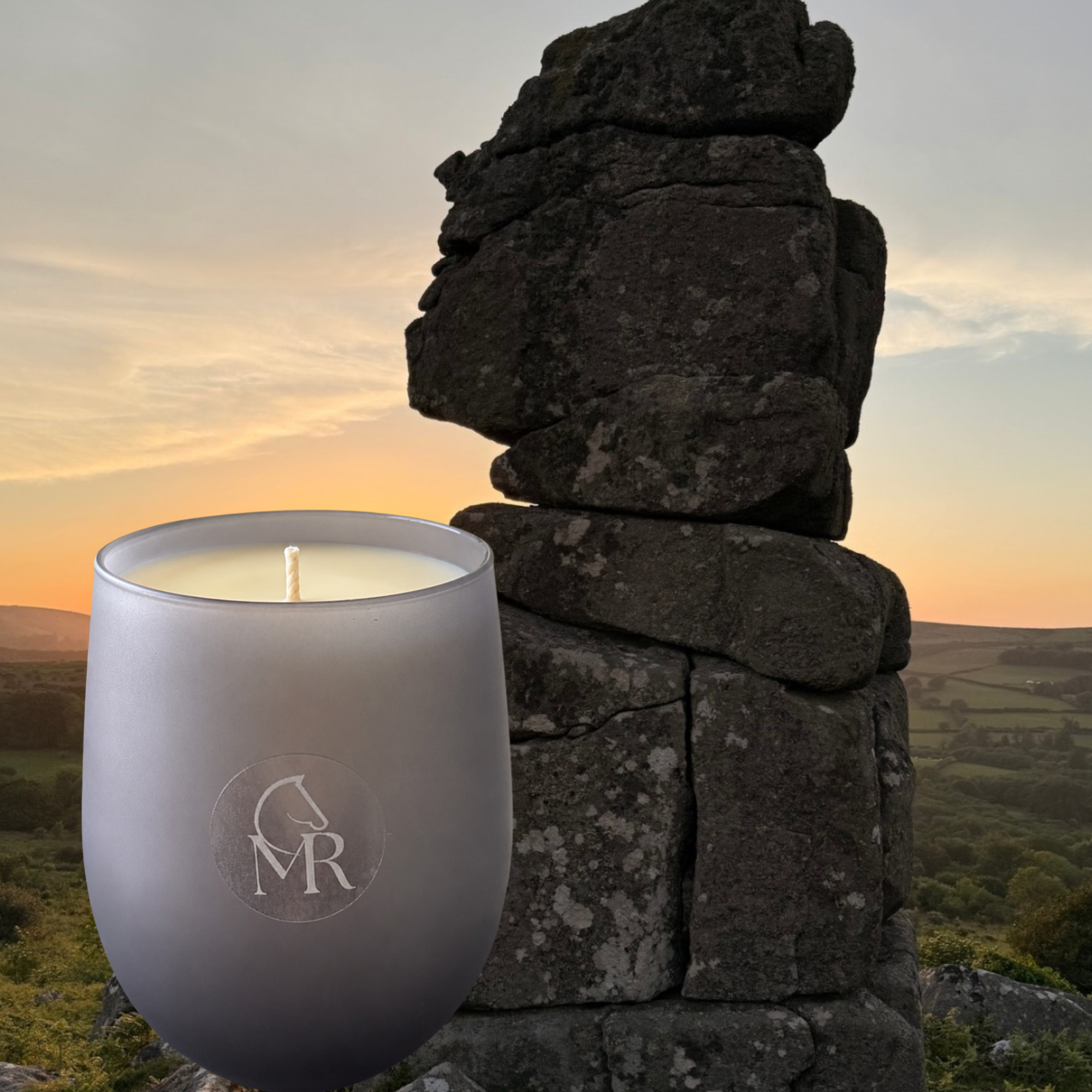 Miss Rio English Pear & Freesia luxury soy candle beside a Dartmoor tor at sunset, inspired by the wild beauty of Dartmoor.