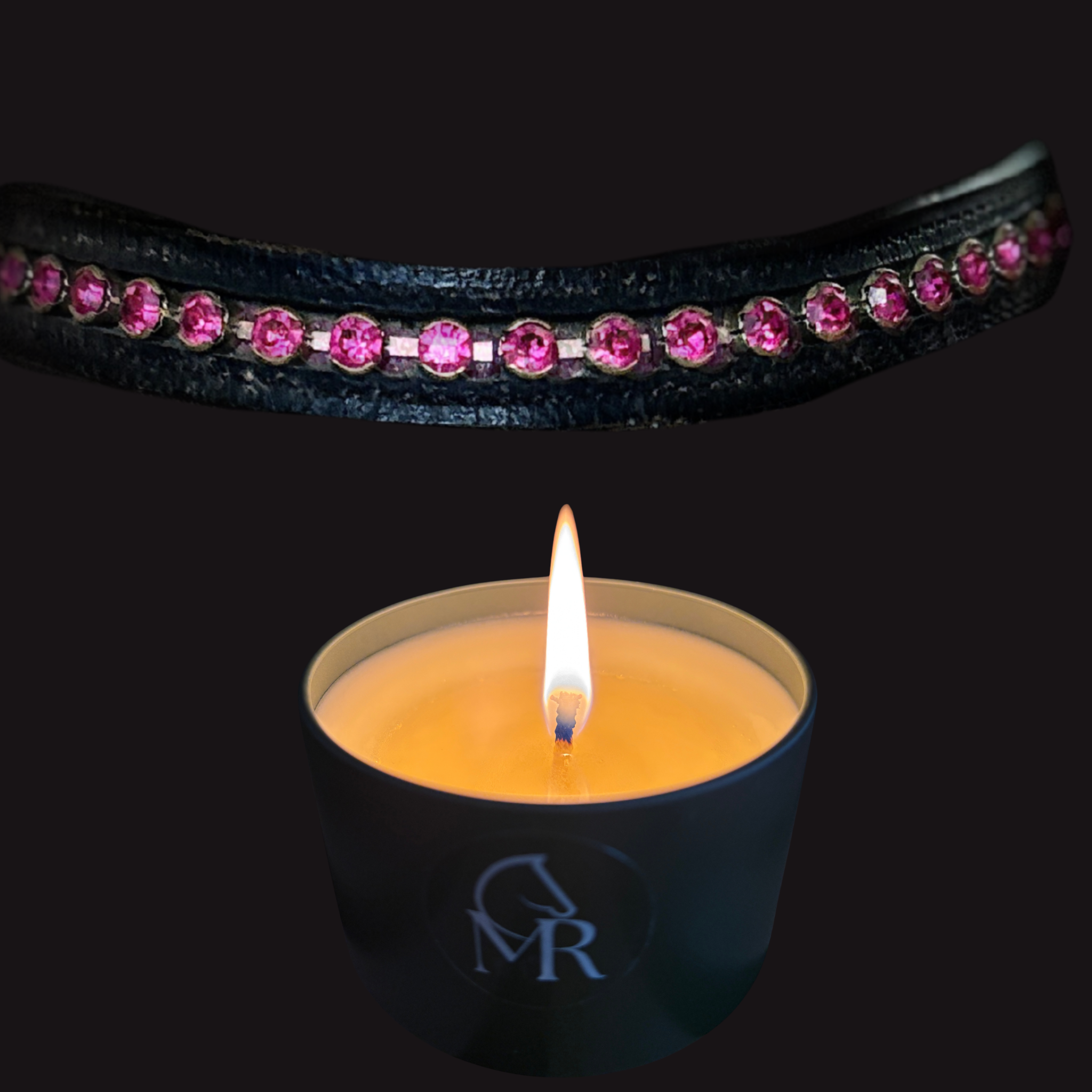 Lit Miss Rio Leather & Tack candle in a matte black travel tin with CMR monogram, photographed beneath a black leather browband set with pink crystals against a dark background.