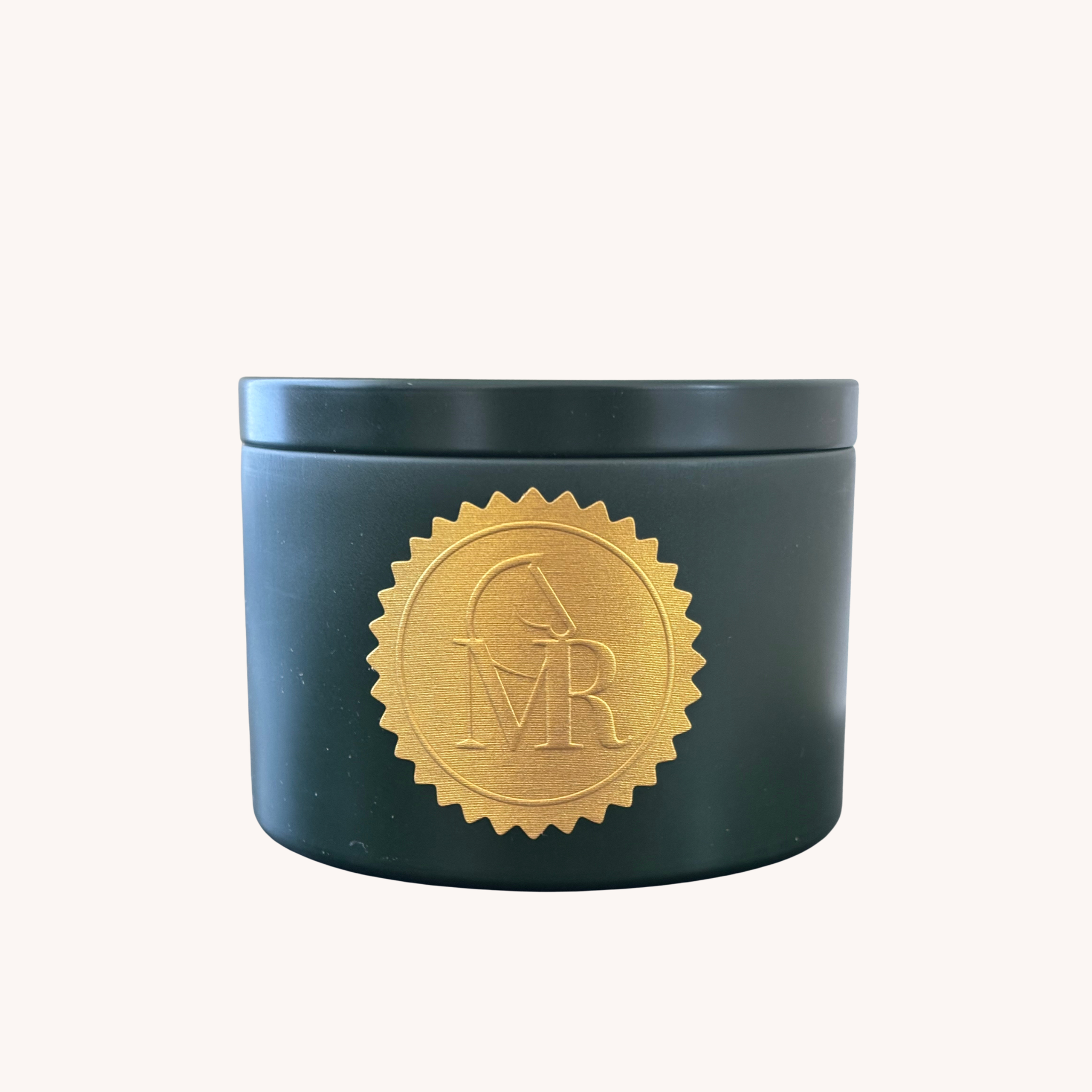 Dark green Miss Rio candle tin with a gold horse seal logo on a white background.the fragrance Tomato vine 