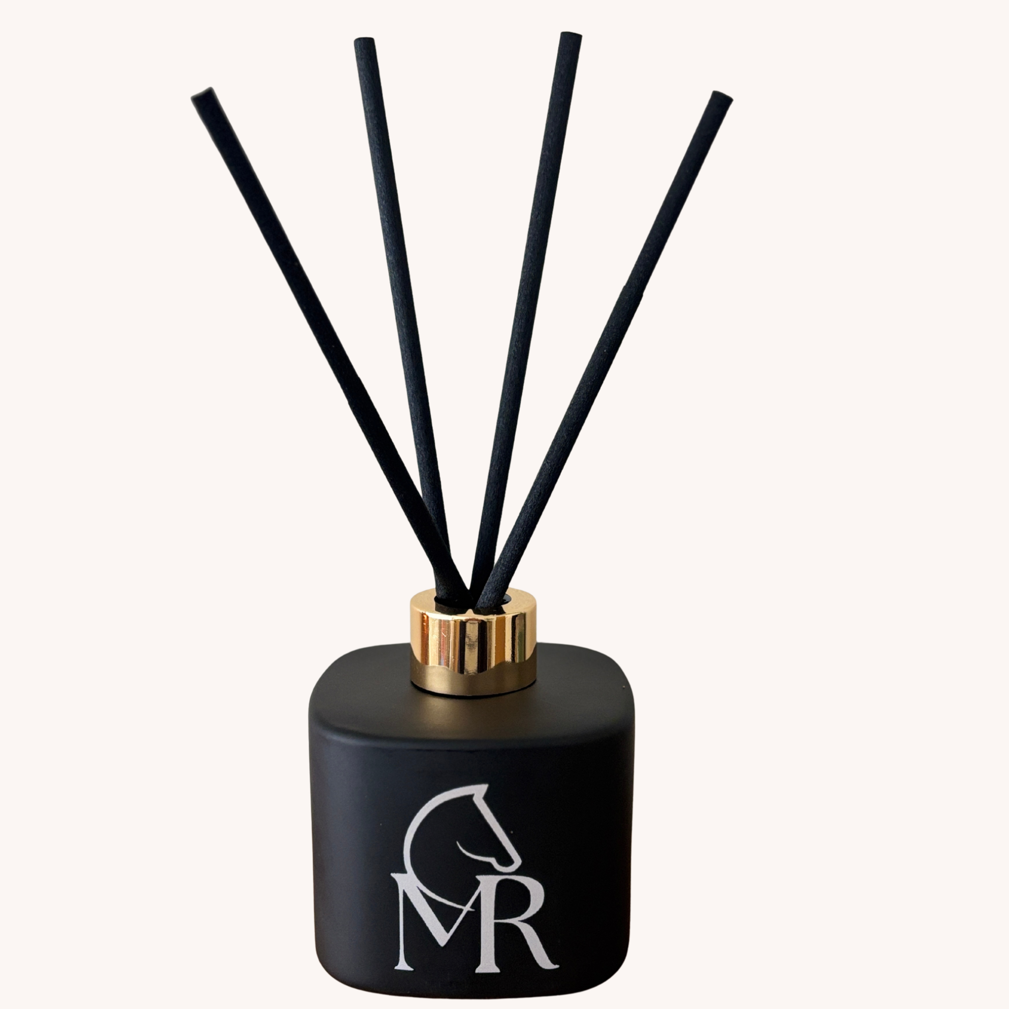 Miss Rio Luxury Reed Diffuser 150ml — black matte vessel with gold collar and MR horse monogram on a white background. Hand-crafted in Devon. Part of The Dandelion Clock Gift Set.