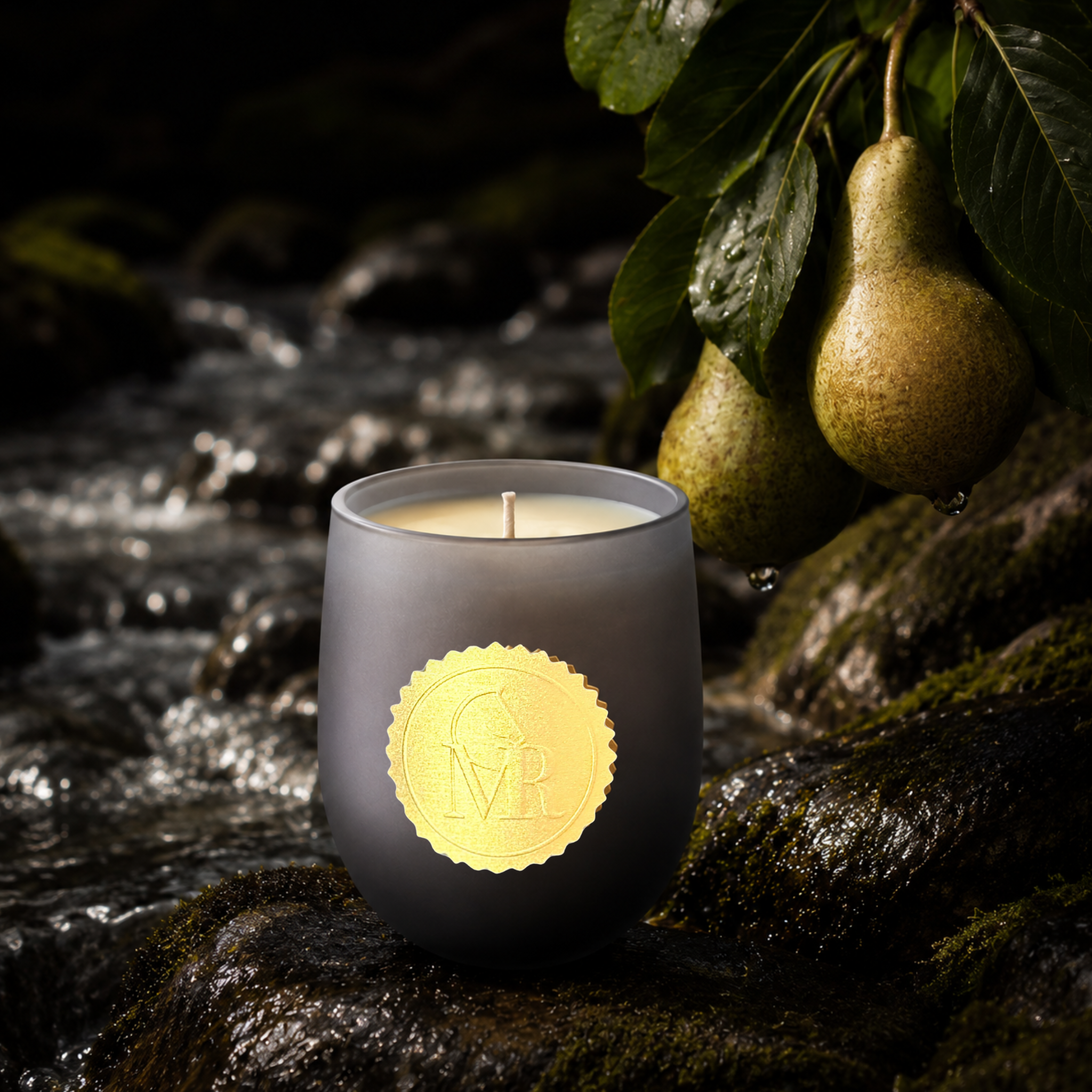 Luxury dark grey Miss Rio candle with a gold MR seal on wet rocks beside a flowing Dartmoor stream, with fresh pears hanging from leafy branches.